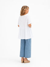 Cargar imagen en el visor de la galería, Blusa de algodón blanca fluida con manga corta y paneles laterales fruncidos diseño elegante y cómodo con modelo lateral