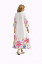 Cargar imagen en el visor de la galería, Vestido de lino blanco con estampado floral multicolor y diseño camisero con botones con modelo de espaldas
