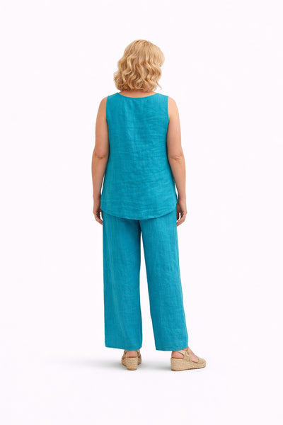 Pantalón de mujer de pernera ancha con cintura elástica y detalles calados verticales, ligero y fluido. Modelo de espaldas